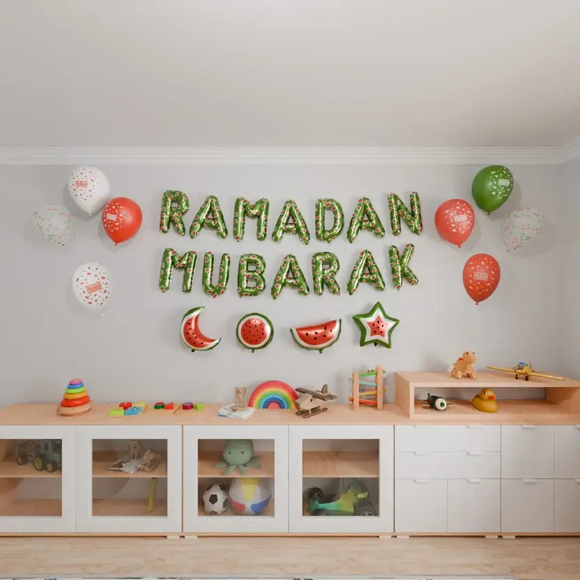 Green Ramadan Mubarak foil letters with watermelon balloons and foil shapes on a playroom wall