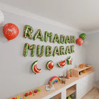 Close-up of green Ramadan Mubarak foil letters with a large red balloon and watermelon foil shapes
