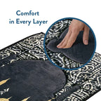 Hand pressing the soft pile of the Dark Arabic Calligraphy padded prayer mat, with its calligraphy border around it