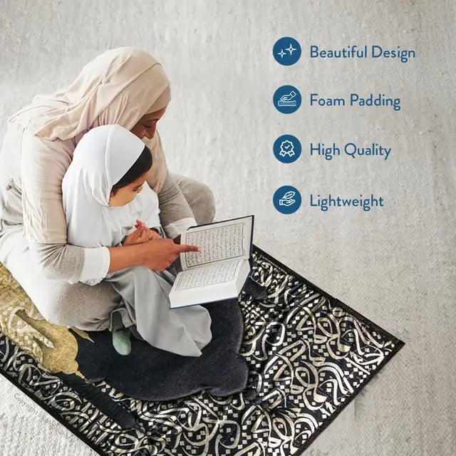 Woman in a hijab and a girl reading a book together on the Dark Arabic Calligraphy padded prayer mat