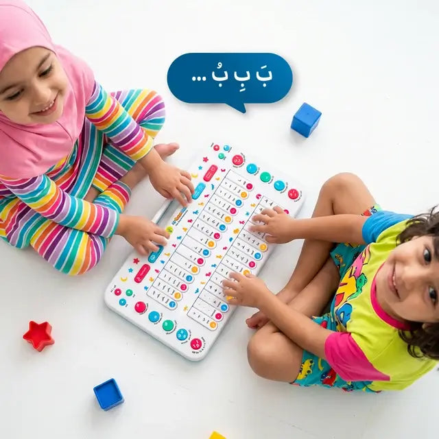Two children on the floor pressing the Arabic letter keys of My Quran Pad, seen from above