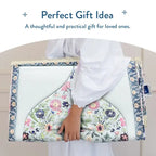 Person in white carrying the folded Spring Blossoms padded prayer mat under one arm