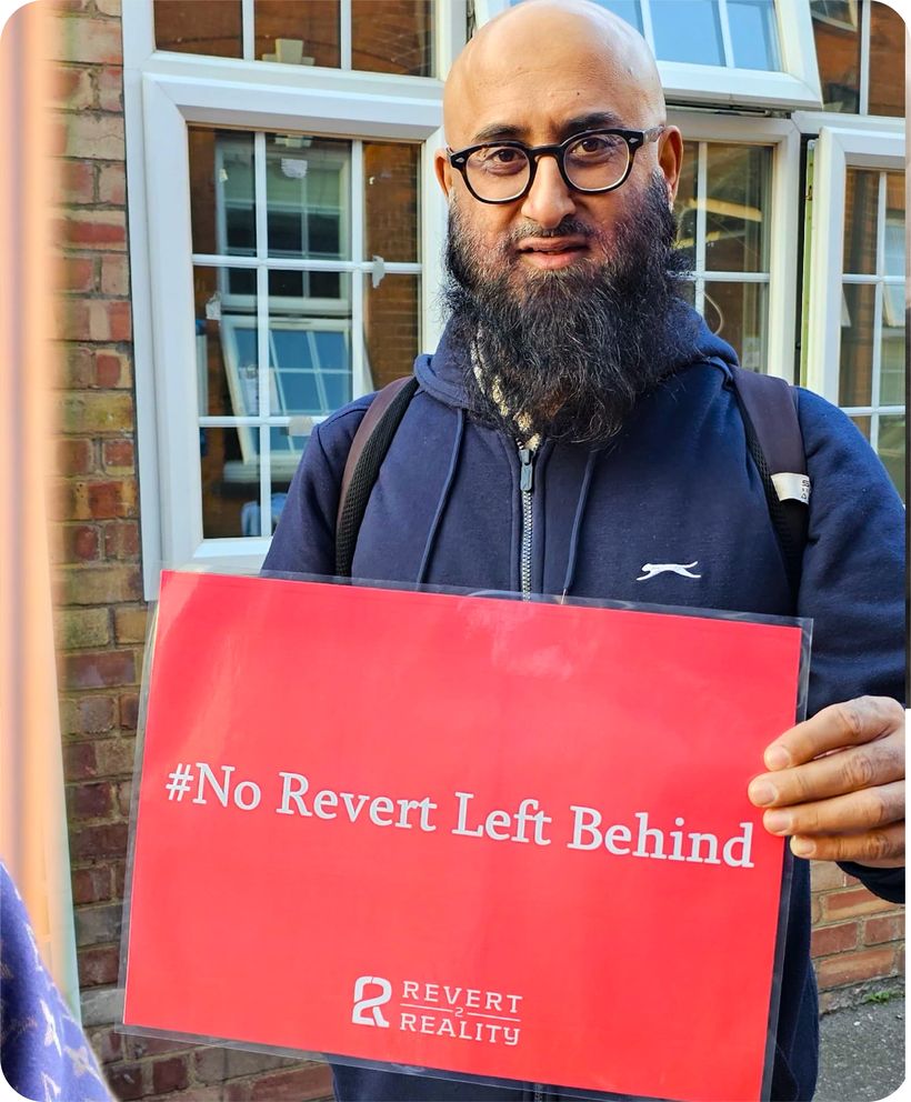 A volunteer holding a No Revert Left Behind sign