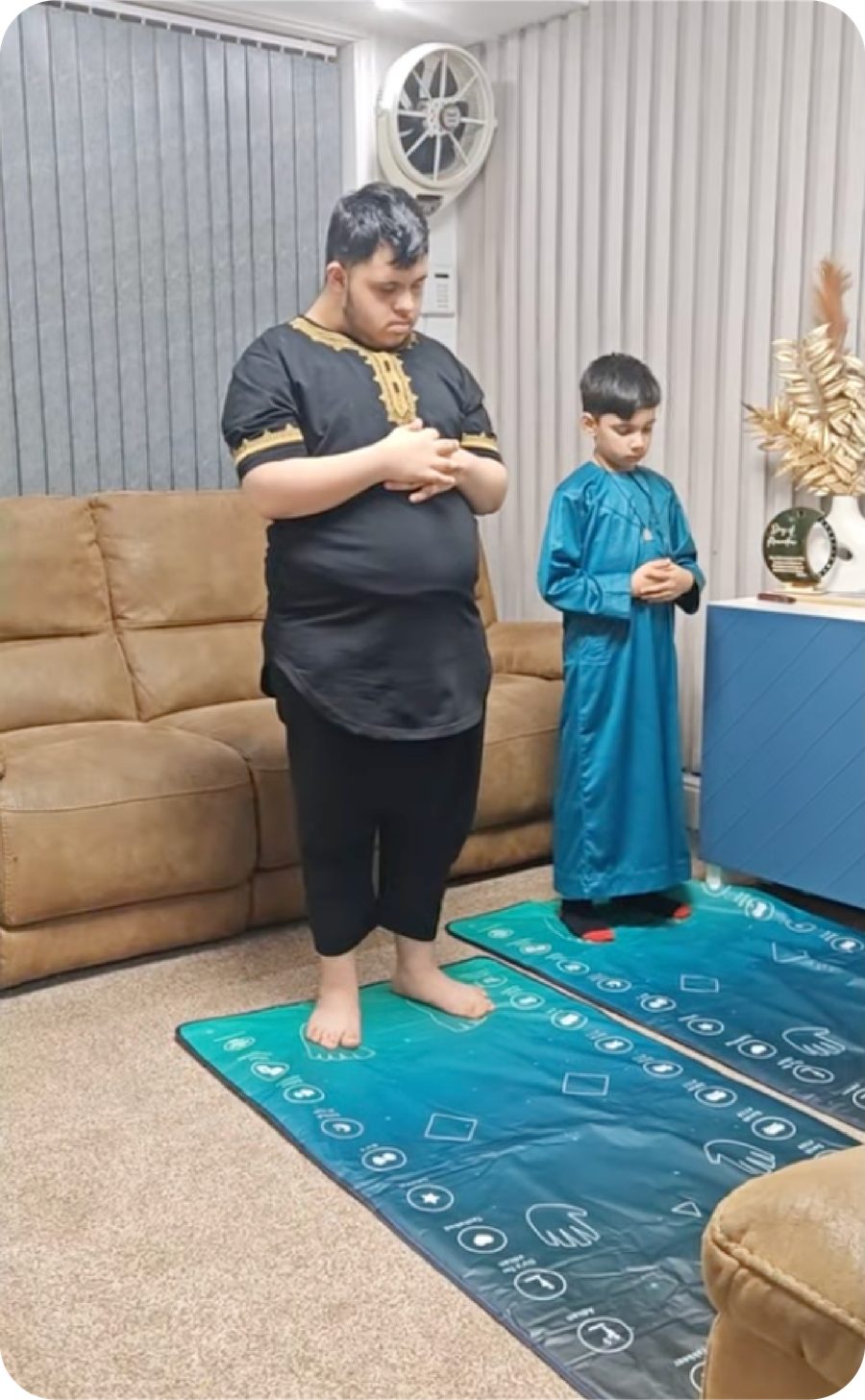 A child standing to pray on the interactive prayer mat at home