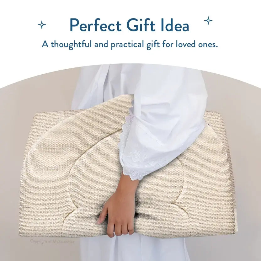 Person in white clothing carrying the folded Luxury Sand Arched padded prayer mat in front of them