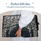 Folded Dark Arabic Calligraphy padded prayer mat carried in both arms, shown as a gift idea